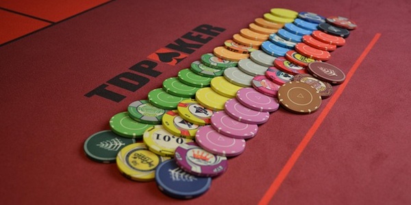Différent jetons de poker sur une table rouge