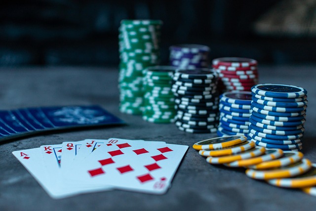 Plusieurs pile de jetons de différentes couleur et une Royal flush en carreau posée sur la table